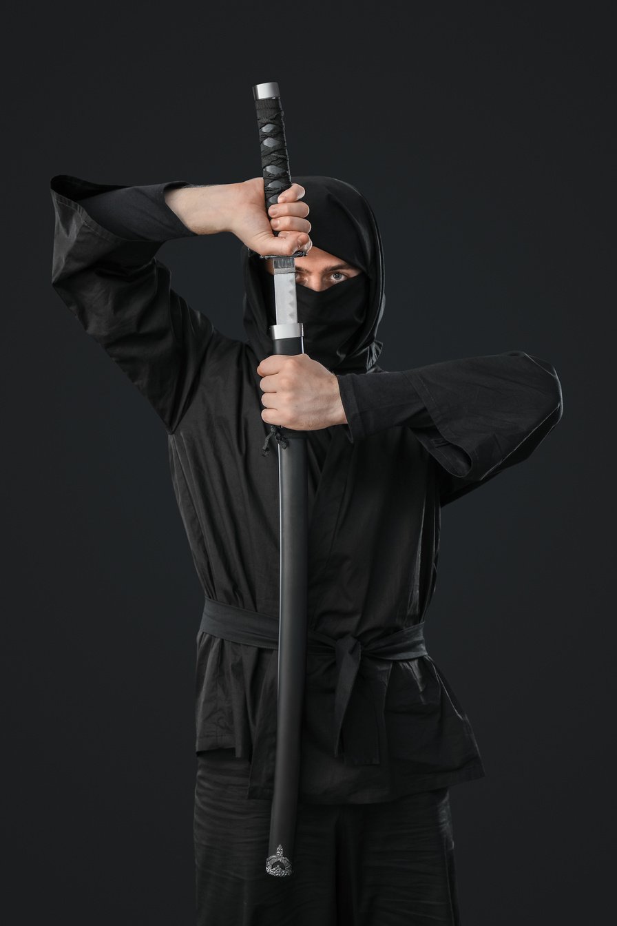 Male Ninja with Sword on Black Background